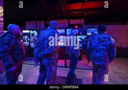 ZAPORIZHZHIA, UKRAINE - 26, 2024 - Soldaten nehmen an der Eröffnung der Fotoausstellung "an der Frontlinie des Lebens" Teil, die Fotos zeigt, die während der Kampfeinsätze des Militärs aufgenommen wurden, organisiert von Soldaten der 116. Separaten Mechanisierten Brigade, im Orbita-Kulturpalast in Zaporischzhia, Südostukraine. Stockfoto