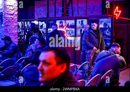 ZAPORIZHZHIA, UKRAINE - 26, 2024 - Soldaten nehmen an der Eröffnung der Fotoausstellung "an der Frontlinie des Lebens" Teil, die Fotos zeigt, die während der Kampfeinsätze des Militärs aufgenommen wurden, organisiert von Soldaten der 116. Separaten Mechanisierten Brigade, im Orbita-Kulturpalast in Zaporischzhia, Südostukraine. Stockfoto