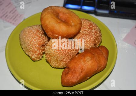 Donuts und Knödel auf einem kleinen Teller auf weißem Hintergrund. Stockfoto
