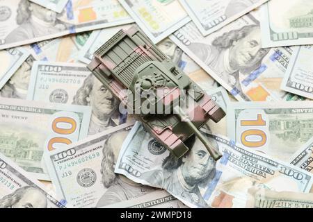 Tank auf zerknitterten 100-Dollar-Banknoten. Hintergrund der Kriegsfinanzierung und des militärischen Unterstützungspreises für die Vereinigten Staaten von Amerika Stockfoto