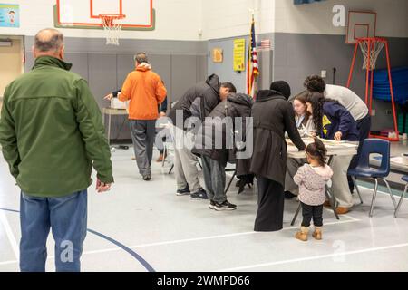 Deaarborn, Michigan, USA. Februar 2024. Die Leute melden sich an der Geer Park School bei der Präsidentschaftswahl in Michigan an. Vor allem in Hamtramck und Dearborn, wo es eine große Zahl von Arabisch-Amerikanern gibt, planten viele Wähler, in der demokratischen Vorwahl „ungebunden“ zu wählen. Viele Araber-Amerikaner sind wütend über Joe Bidens Unterstützung für Israel im Gaza-Krieg. Quelle: Jim West/Alamy Live News Stockfoto