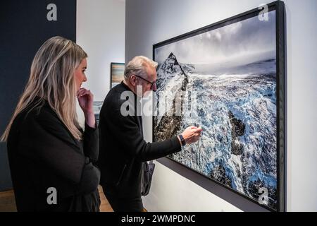 London, Großbritannien. Februar 2024. Der Künstler untersucht Coast Mountains #20, Monarch of Ice Cap, British Columbia, Kanada, 2023 mit einem Mitarbeiter der Galerie - Edward Burtynsky, New Works, eine Einzelausstellung in der Flowers Gallery, London. Dies fällt mit der Retrospektive der Saatchi-Galerie zusammen. Diese Ausstellung findet vom 27. Februar bis 6. April 2024 statt. Guy Bell/Alamy Live News Stockfoto