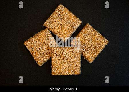 Bis Chikki auf schwarzgrauem Hintergrund. Till Chikki ist ein indisches Süßwarengericht, das mit Jaggery und Sesam zubereitet wird. Indisches Festival makar sankranti besonderes Süßes Stockfoto