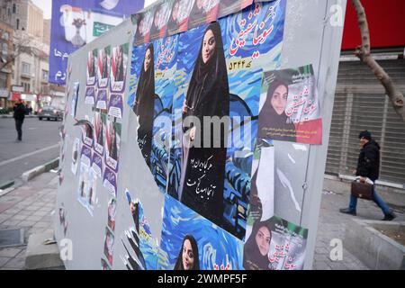 Teheran, Iran. Februar 2024. Ein iranischer Mann läuft neben den Wahlplakaten der Kandidaten, die bei den bevorstehenden Parlamentswahlen antreten, auf einer Straße in Teheran. Die iranischen Wähler werden am 1. März ihre Stimmzettel abgeben, um neue Mitglieder des iranischen parlaments und der Expertenversammlung auszuwählen, einem wichtigen Gremium, das den obersten Führer des Landes ernennt. (Kreditbild: © Rouzbeh Fouladi/ZUMA Press Wire) NUR REDAKTIONELLE VERWENDUNG! Nicht für kommerzielle ZWECKE! Stockfoto