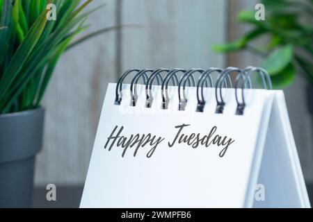 Happy tuesday Text auf weißem Kalender mit Topfpflanzen Hintergrund. Stockfoto