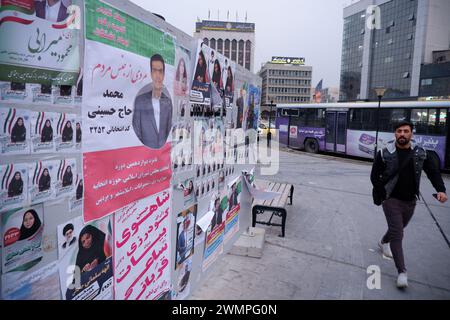 Teheran, Iran. Februar 2024. Ein iranischer Mann läuft neben den Wahlplakaten der Kandidaten, die bei den bevorstehenden Parlamentswahlen antreten, auf einer Straße in Teheran. Die iranischen Wähler werden am 1. März ihre Stimmzettel abgeben, um neue Mitglieder des iranischen parlaments und der Expertenversammlung auszuwählen, einem wichtigen Gremium, das den obersten Führer des Landes ernennt. (Kreditbild: © Rouzbeh Fouladi/ZUMA Press Wire) NUR REDAKTIONELLE VERWENDUNG! Nicht für kommerzielle ZWECKE! Stockfoto