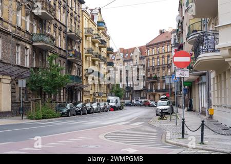 Posen, Polen – 18. Juni 2023: Eine Straße, die von Parkwagen auf beiden Seiten gesäumt ist, schafft eine geschäftige urbane Szene. Stockfoto