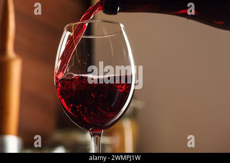 Rotwein wird in ein Glas gegossen Stockfoto