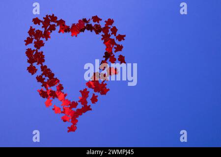 Herz aus kleinen Cupiden auf blauem Hintergrund. Kopierbereich. Flache Lagen Stockfoto