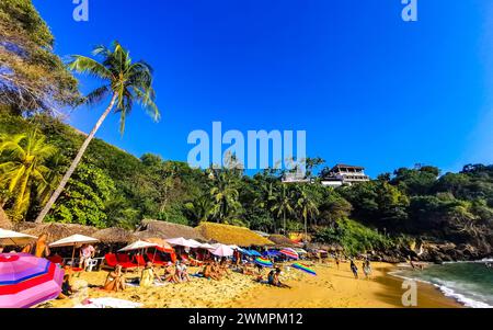 Puerto Escondido Oaxaca Mexiko 14. November 2022 Beach Sand Türkis Blue Water Rocks Cliffs Boulders Sonnenliegen People Palmen Und Riesige Big Sur Stockfoto