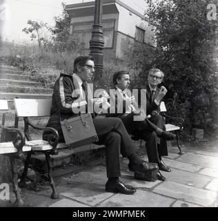 1970er Jahre, historisch, drei männliche Transportarbeiter, entweder U-Bahn- oder Busfahrer, sitzen auf einer Bank und machen eine Mittagspause, England, Großbritannien. Stockfoto