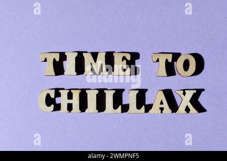 Zeit für Chillax, eine Wortkombination aus Chill and Relax, bekannt als Portmanteau, in hölzernen Alphabeten isoliert auf violettem Hintergrund Stockfoto