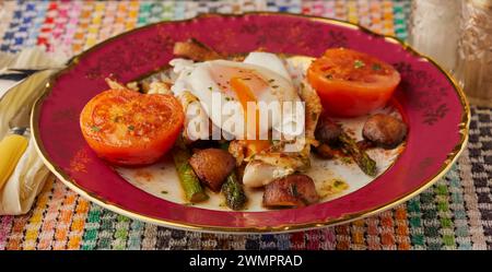 Weißfischfilet auf einem Bett aus Pilzen und Spargel und garniert mit einem pochierten Ei. Stockfoto