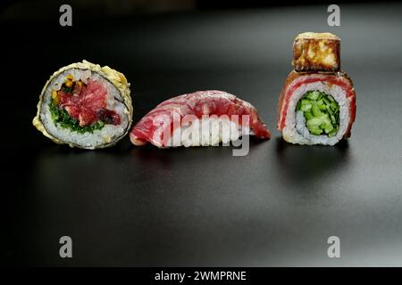 Verschiedene Sushi-Brötchen ordentlich auf einem Tisch angeordnet Stockfoto