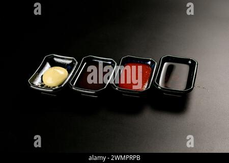 Verschiedene kleine Behälter gefüllt mit verschiedenen Soßen, Brühe und Ketchup Stockfoto