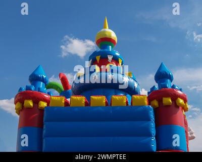 Federnd aufblasbares Schloss im Freien. Kinderspielplatz zur freien Verfügung. Spaß, Spiel, Unterhaltung, Fahrt. Farbenfroh, mehrfarbig. Kinder. Stockfoto