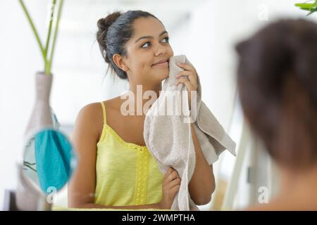 Frau, die ihr Gesicht mit einem Handtuch trocken klopft Stockfoto