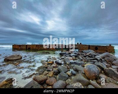 Felsbrocken am Strand am Wasser mit großen Wellen Stockfoto