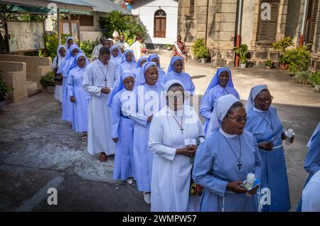 Katholische Nonnen und Seminaristen singen, während sie die St. Joseph's Cathedral zur katholischen Sonntagsmesse in Stone Town, Sansibar, Tansania betreten. Stockfoto