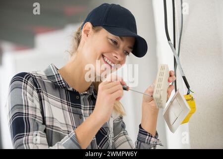 Lächelnde junge Elektrikerin Stockfoto
