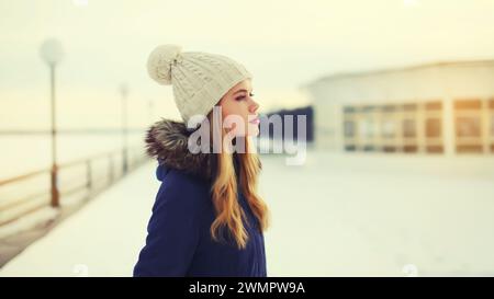 Porträt einer schönen blonden jungen Frau, die im Winter draußen im Park posiert Stockfoto