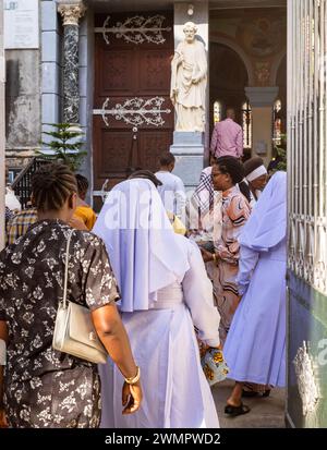 Katholische Nonnen und andere sonntags gekleidete Personen kommen am besten zur St. Joseph's Cathedral zur Sonntagsmesse in Stone Town, Sansibar, Tansania Stockfoto
