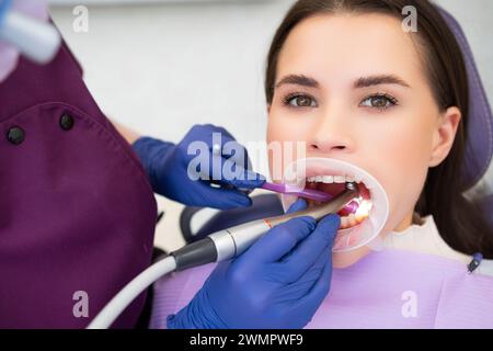 Junge schöne Frau wird in der Zahnarztpraxis Zahnfüllungen unterzogen Stockfoto