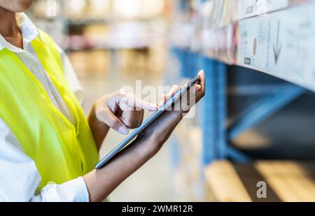 Lagermitarbeiter verwenden ein Tablet, um wichtige Informationen zu prüfen Stockfoto