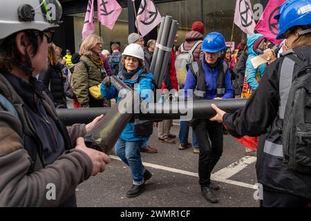 London, UK, 27. Februar 2024, Versichern Sie Sich Unsere Zukünftige Rallye & March. Extinction Rebellion Protest durch die Straßen der City of London. Die Demonstranten halten an und besetzen die Büros der Versicherungsgesellschaften, die sie für die Unterstützung der fossilen Brennstoffindustrie verantwortlich machen. Kredit: James Willoughby Stockfoto