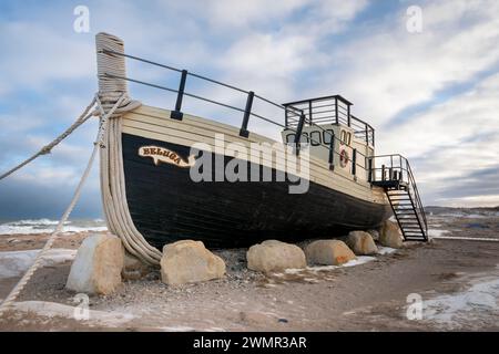 Ein Boot am Strand dient gleichzeitig als Aussichtsplattform mit Blick auf die Küste der Hudson Bay in der Stadt Churchill, Manitoba, Kanada Stockfoto