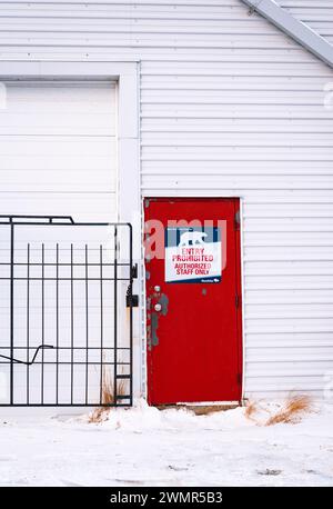 Außenansicht der roten Tür zur Eisbärenauffangeinrichtung in Churchill, Manitoba, Kanada, bekannt als Polar Bear Jail. Stockfoto