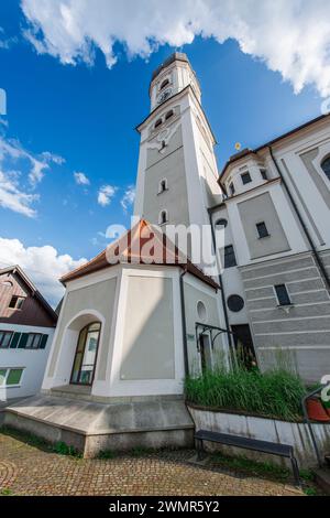 Nesselwang, Deutschland - 06. Juli 2023: Weitwinkel-Nordansicht der St. Andreas-Kirche mit Glockenturm und Turmkapelle vor blauem Himmel. Stockfoto