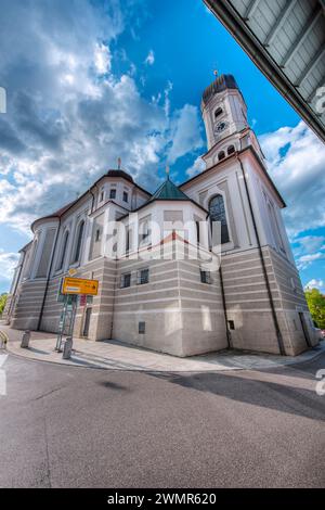 Nesselwang, Deutschland - 06. Juli 2023: Südöstliche Ecke der St. Andreas-Kirche mit Wegweisern und Blick auf die Straßenkreuzung nach Marktoberdorf. Stockfoto