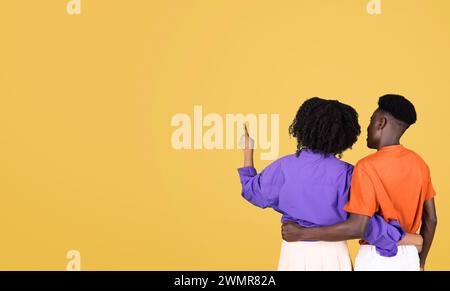 Rückansicht eines jungen Paares, das zusammen steht, die Frau in einer lila Bluse Stockfoto
