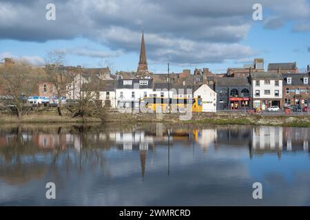 Ein Blick über den Fluss Nith mit den Whitesands in Dumfries, Schottland. Bei der Ankunft eines Stagecoach-Busses werden Passagiere abgeholt. Stockfoto