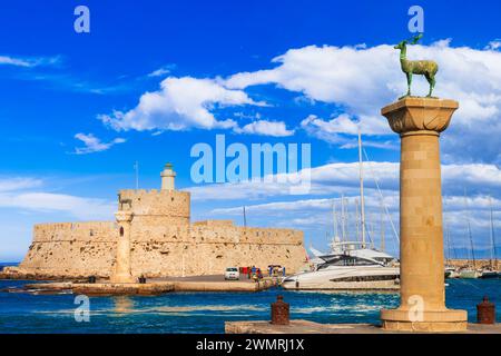 Griechenland Reise, Dodekanese. Rhodos. Eingang des Hafens von Mandraki mit der Statue des Hirsches und dem alten Leuchtturm Stockfoto