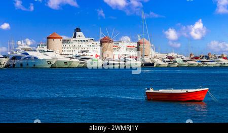 Griechenland Reise, Dodekanese. Rhodos. Mandraki Harbor mit Kreuzfahrtschiffen und alten Windmühlen Stockfoto