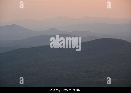 Bergsilhouette bei Sonnenuntergang an einem heißen Sommertag mit sehr hoher Luftfeuchtigkeit Stockfoto