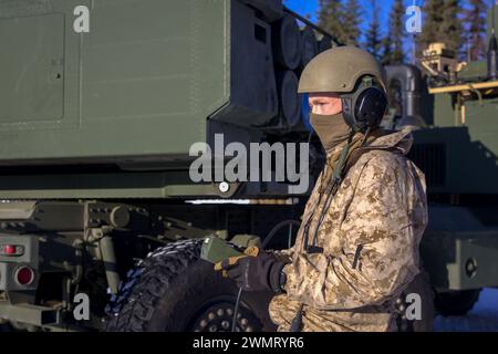 Ein U.S. Marine mit Fox Battery, 2nd Battalion, 14th Marine Regiment, 4th Marine Division, Marine Forces Reserve führt eine simulierte Nachladung auf einem High Mobility Artillery Rocket System (HIMARS) während der Übung Arctic Edge 2024 auf der Eielson Air Force Base, Alaska, 23. Februar 2024 durch. Als Teil der Fähigkeiten der Marine Air-Ground Task Force (MAGTF) trägt das HIMARS-Waffensystem erheblich zur Energieprojektion und zur präzisen Feuerunterstützung der MAGTF für Marines in verschiedenen Szenarien, einschließlich in arktischen Umgebungen, bei, wodurch die Gesamteffizienz und Vielseitigkeit verbessert werden. Arctic Edge 2024 (AE24) i Stockfoto