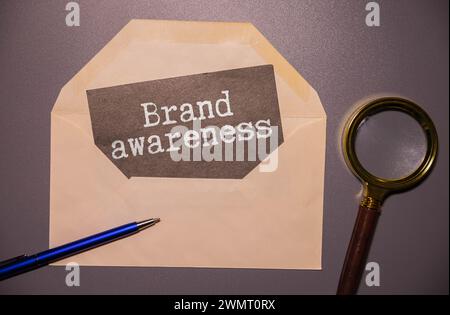 Geschäftsmann zeigt ein Banner mit der Botschaft Markenbewusstsein. Konzept für das Branding der Unternehmensmarketing-Strategie Stockfoto