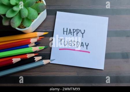 Konzept des Happy Tuesday Schreibens auf Haftnotizen isoliert auf Holztisch. Stockfoto