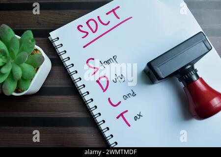 Konzept der SDLT - Stempelgebühr Grundsteuer auf Buch isoliert auf Holztisch schreiben. Stockfoto