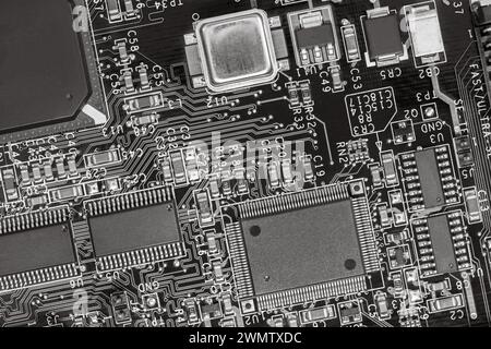 Großansicht der Leiterplatte mit Widerständen, Kondensatoren, Mikrochips und elektronischen Bauteilen. s/mit Stockfoto