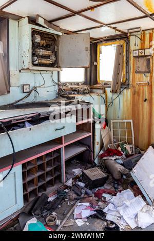 Radhaus eines abgerissenen Frachtschiffswracks nach einer Schiffskatastrophe, Innenansicht des Schreibtisches mit Kommunikationsgeräten und -Ausrüstung, Al Hamriyah Beach, VAE Stockfoto