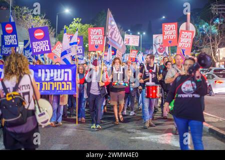 Haifa, Israel - 24. Februar 2024: Menschen marschieren mit verschiedenen Zeichen und Flaggen aus Protest gegen die Regierung und rufen zu Neuwahlen auf. Haifa, Isra Stockfoto