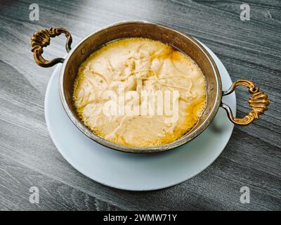 Traditionelle türkische Mahlzeit namens Mihlama oder Kuymak, serviert in einer heißen Pfanne. Beliebte Küche der Schwarzmeerregion der Türkei. Seine Hauptbestandteile sind Mais Stockfoto