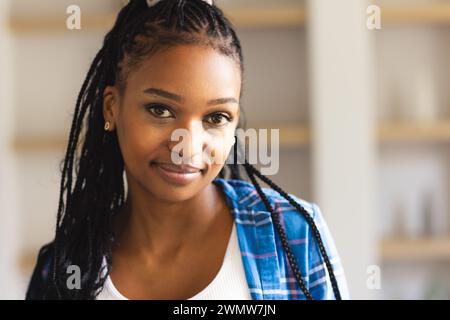 Eine junge Afroamerikanerin mit geflochtenem Haar lächelt sanft in die Kamera Stockfoto