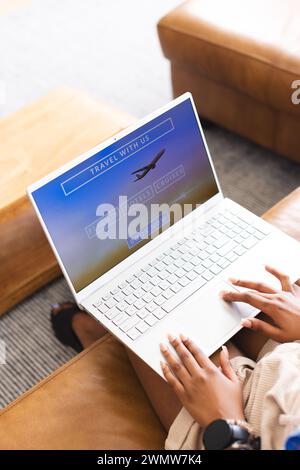 Eine Person durchsucht auf einem Laptop eine Reise-Website Stockfoto