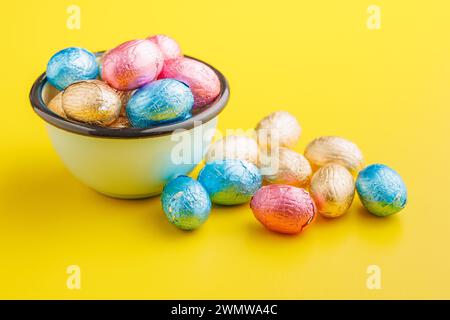 Osterschokoladeneier in Aluminiumfolie auf gelbem Hintergrund. Stockfoto