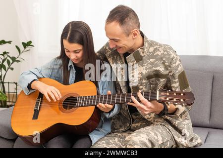 Ein Veteran und seine Tochter spielen Gitarre Stockfoto